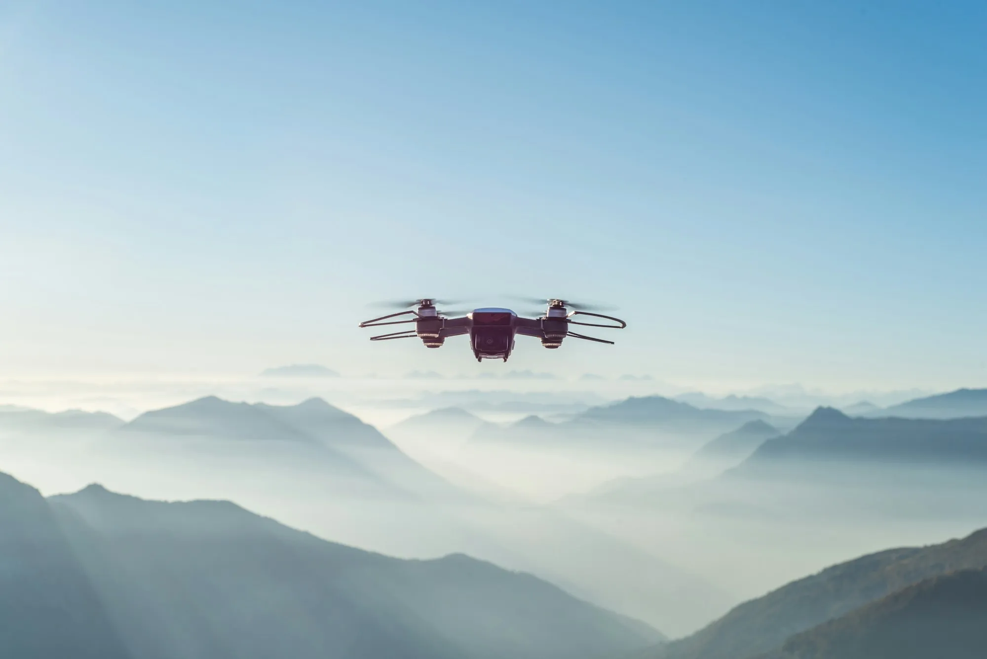 Drone flying high above misty hills